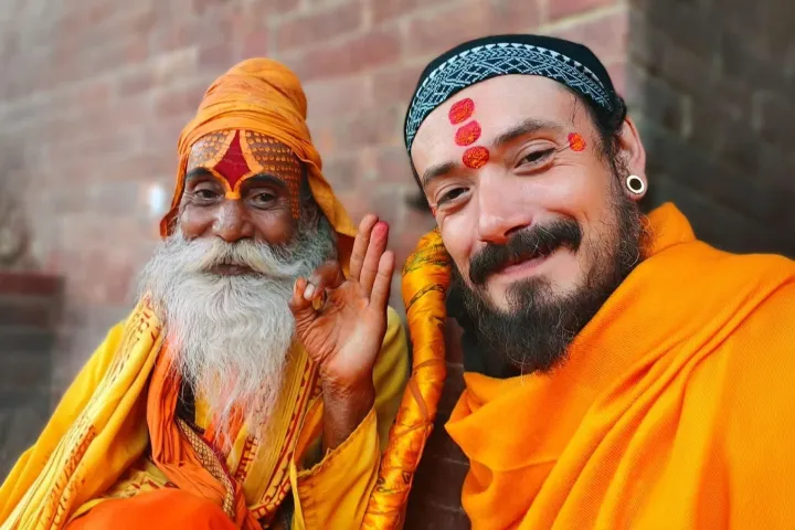 Au Népal, un pratiquant auprès de Ram Baba, sadhu, devant un mur de briques